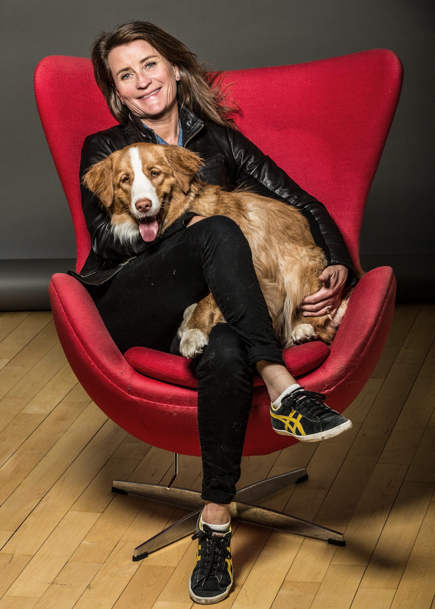 A Compass agent with her dog in a red chair